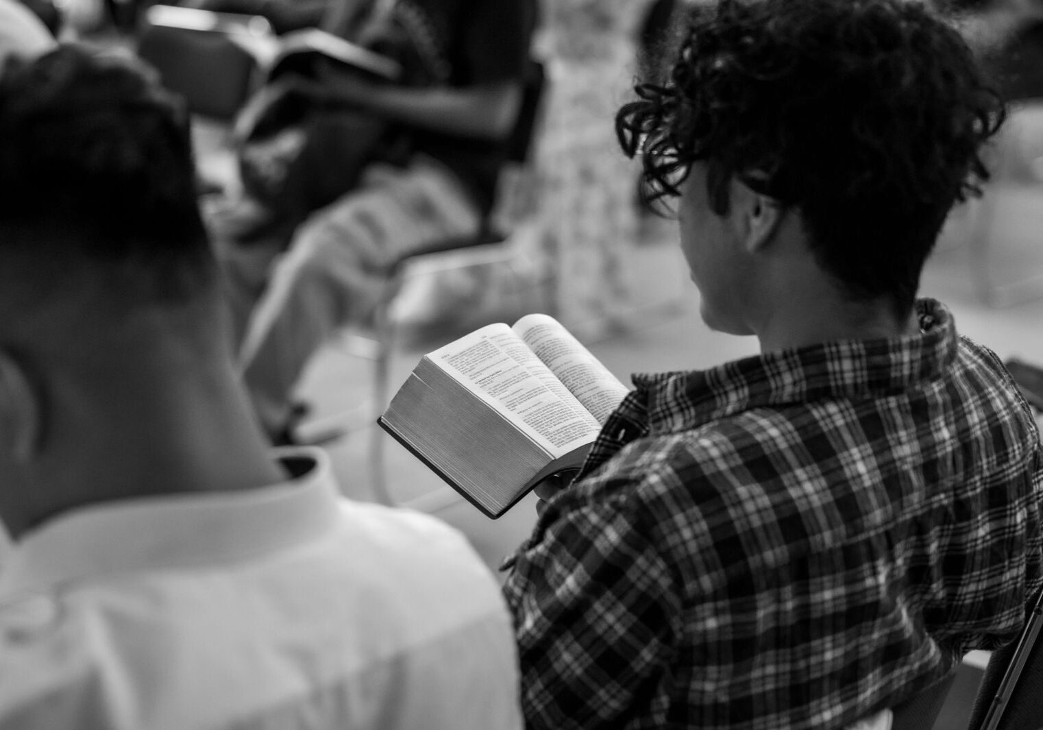 A young man reads a Bible in a prayer group setting in Ciudad de México.